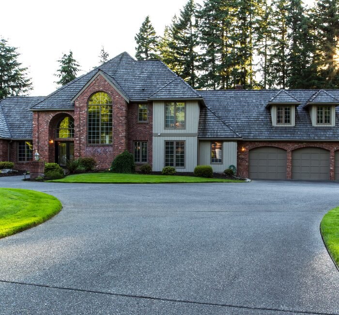 Textured concrete driveway in Spokane, WA, leading to a large home.