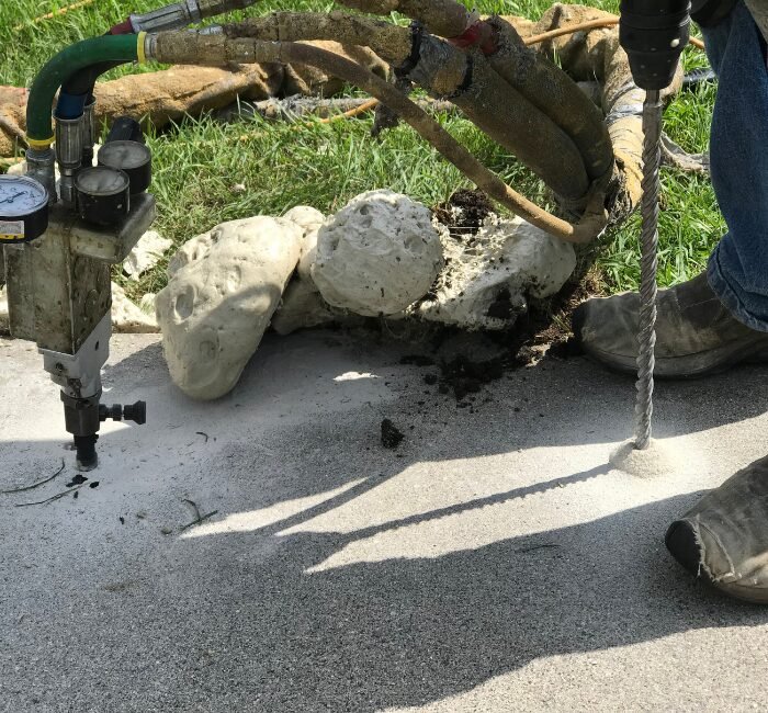 Contractor in Spokane repairing a sidewalk with mudjacking technique.